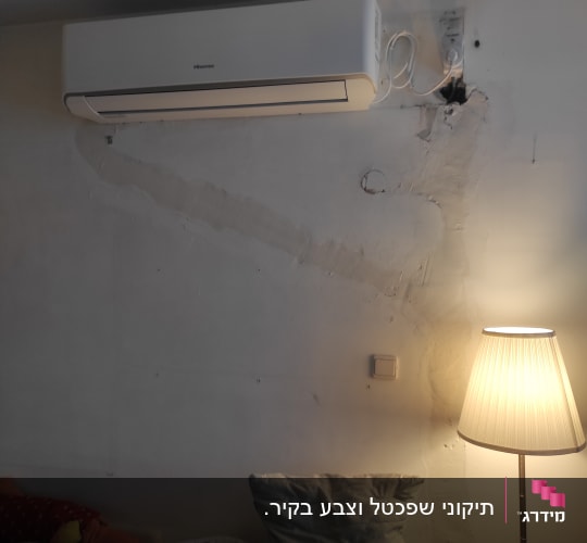 מזגן מותקן על קיר עם חוטי חשמל גלויים